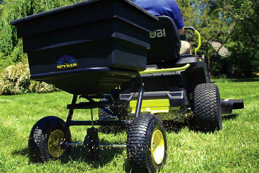 lawn care professional using fertilizer spreaders